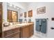 Bathroom featuring granite countertops, dark wood cabinets, decorative mirror, and ample storage space at 229 Riverbend Rd, Ormond Beach, FL 32174