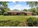 Beautiful brick home with a well-manicured lawn, lush greenery, and charming architectural details that enhance its curb appeal at 229 Riverbend Rd, Ormond Beach, FL 32174