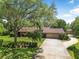 Stunning shot of the brick home, long driveway and lush landscaping at 229 Riverbend Rd, Ormond Beach, FL 32174