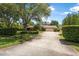 Charming home with a large front yard, mature trees, lush landscaping, and a long driveway leading to a two-car garage at 229 Riverbend Rd, Ormond Beach, FL 32174