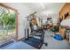 Workout equipment inside the garage with a door leading out to a fenced yard at 229 Riverbend Rd, Ormond Beach, FL 32174