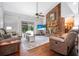 Bright living room with hardwood floors, a brick fireplace, and sliding glass doors leading to the backyard at 229 Riverbend Rd, Ormond Beach, FL 32174