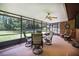 Enclosed screen porch with seating, a ceiling fan, and views of the backyard at 229 Riverbend Rd, Ormond Beach, FL 32174