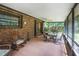 Relaxing screened porch with ceiling fan, furniture, and brick siding at 229 Riverbend Rd, Ormond Beach, FL 32174