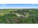 Aerial view of rural property with barn, house, surrounding by sprawling pastures and dense woodlands at 2395 Old Reynolds Rd, De Leon Springs, FL 32130