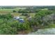 Aerial view featuring the home, storage building, RV, mature trees, and a serene pond at 2395 Old Reynolds Rd, De Leon Springs, FL 32130
