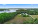 Expansive aerial view of the property, showcasing the home, surrounding land, lake, and lush greenery at 2395 Old Reynolds Rd, De Leon Springs, FL 32130