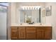 Bathroom boasting double sinks, wood cabinets, a large mirror and bright lighting at 2395 Old Reynolds Rd, De Leon Springs, FL 32130