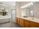 Bathroom featuring double vanity, wood cabinets, glass shower, tub and bright lighting at 2395 Old Reynolds Rd, De Leon Springs, FL 32130
