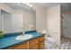 Bright bathroom features a large mirror, single sink vanity with a blue countertop, and tiled floors at 2395 Old Reynolds Rd, De Leon Springs, FL 32130