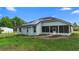 Exterior side view of a home with solar panels on roof, screen patio, and fenced yard at 2395 Old Reynolds Rd, De Leon Springs, FL 32130