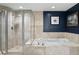 Modern bathroom featuring a glass-enclosed shower, a luxurious soaking tub, and elegant tile work at 241 Riverside Dr # 1909, Daytona Beach, FL 32117