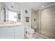 This bathroom features a vanity with storage, toilet, and glass-enclosed shower with tiled floors at 241 Riverside Dr # 1909, Daytona Beach, FL 32117