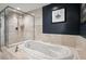 Modern bathroom featuring a glass-enclosed shower, a luxurious soaking tub, and elegant tile work at 241 Riverside Dr # 1909, Daytona Beach, FL 32117