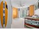 Bright bedroom with vibrant orange walls and a sliding glass door leading to a balcony at 241 Riverside Dr # 1909, Daytona Beach, FL 32117