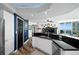 Open kitchen view, modern white cabinets, dark counters, and access to the living room at 241 Riverside Dr # 1909, Daytona Beach, FL 32117