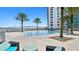 Beautiful pool area with bridge view, palm trees, lounge chairs, and seating for relaxation at 241 Riverside Dr # 1909, Daytona Beach, FL 32117