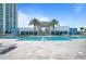 Beautiful resort-style pool with lounge chairs, palm trees, and an open-air covered pavilion near the ocean at 241 Riverside Dr # 1909, Daytona Beach, FL 32117