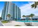 Resort-style pool and sundeck with white condo building backdrop on sunny day at desirable coastal living community at 241 Riverside Dr # 1909, Daytona Beach, FL 32117