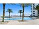 Stunning pool area with palm trees and plenty of lounge chairs near the water with a beautiful view at 241 Riverside Dr # 1909, Daytona Beach, FL 32117