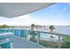 Enjoy a beautiful pool and waterfront view from the condo's balcony with glass railings and patio furniture at 241 Riverside Dr # 304, Daytona Beach, FL 32117