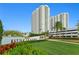 Beautiful high-rise building with manicured landscaping and a clear blue sky backdrop at 241 Riverside Dr # 304, Daytona Beach, FL 32117