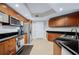 Open kitchen with wood cabinets, stainless appliances, tile floor, and dark countertops at 241 Riverside Dr # 304, Daytona Beach, FL 32117