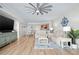 Open-concept living space featuring wood floors, comfortable furniture, and a glimpse into the kitchen area at 241 Riverside Dr # 304, Daytona Beach, FL 32117