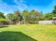 Large backyard with a mature tree line, a shed, and a small fire pit at 243 S Hull Ave, Deland, FL 32720