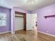 This bedroom features hardwood floors, lilac-painted walls, a closet, and a window view at 243 S Hull Ave, Deland, FL 32720