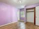 This bedroom features hardwood floors, lilac-painted walls, a closet, and a window view at 243 S Hull Ave, Deland, FL 32720
