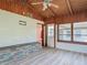 Bright sunroom with tile floors, wood walls, and large windows with ceiling fan at 243 S Hull Ave, Deland, FL 32720