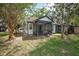 Charming backyard features a cozy screened-in porch surrounded by lush trees and a well-maintained lawn at 2596 Lancaster Ct, Apopka, FL 32703