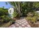 Backyard shed with tiled walkway surrounded by tropical landscaping at 265 S Fairbairn Dr, Deltona, FL 32725