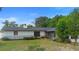 Backyard with lush greenery, a screened-in porch, and partial brick siding for a charming exterior at 265 S Fairbairn Dr, Deltona, FL 32725