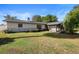 Backyard view showcasing lush green lawn and partial white brick siding for the home's exterior at 265 S Fairbairn Dr, Deltona, FL 32725