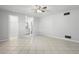 Bedroom features tile flooring, ceiling fan, and view into the bathroom and closet area at 265 S Fairbairn Dr, Deltona, FL 32725
