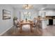 A dining room with seating for six, next to a kitchen and sliding glass door to an outdoor living space at 265 S Fairbairn Dr, Deltona, FL 32725