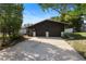 Home exterior featuring a two-car garage, driveway, and mature trees at 265 S Fairbairn Dr, Deltona, FL 32725