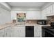A bright kitchen featuring white cabinetry, modern appliances, and updated countertops and backsplash at 265 S Fairbairn Dr, Deltona, FL 32725