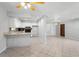 Open-concept kitchen with white cabinets, tile backsplash, and a breakfast bar overlooking the living space at 265 S Fairbairn Dr, Deltona, FL 32725