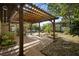 Inviting outdoor patio featuring a wooden pergola, brick flooring, and lush greenery at 265 S Fairbairn Dr, Deltona, FL 32725