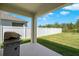 Covered patio area with a barbecue grill and a white vinyl privacy fence at 2686 Neverland Dr, New Smyrna Beach, FL 32168