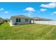 Well-maintained backyard featuring lush green grass, clean white gravel, and vinyl fencing at 2686 Neverland Dr, New Smyrna Beach, FL 32168