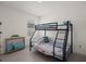 Bedroom with light floors and neutral walls featuring a bunk bed with a blue frame and colorful ocean-themed bedding at 2686 Neverland Dr, New Smyrna Beach, FL 32168