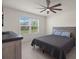 Bedroom featuring light floors, neutral walls, a ceiling fan, and a window with a view of trees and the sky at 2686 Neverland Dr, New Smyrna Beach, FL 32168