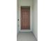 Close up shot of a beautifully designed brown wooden front door at 2686 Neverland Dr, New Smyrna Beach, FL 32168