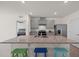 Modern kitchen featuring gray cabinets, granite countertops, stainless steel appliances, and an island with barstool seating at 2686 Neverland Dr, New Smyrna Beach, FL 32168