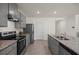 Modern kitchen features stainless steel appliances, gray cabinets, and granite countertops with an island and tile floors at 2686 Neverland Dr, New Smyrna Beach, FL 32168