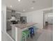 Modern kitchen boasts gray cabinets, stainless steel appliances, and a granite countertop island with colorful seating at 2686 Neverland Dr, New Smyrna Beach, FL 32168